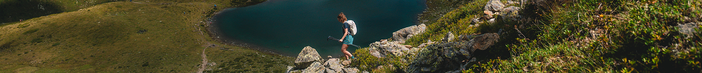 Female hiker going down a mountain range in their Gregory pack.